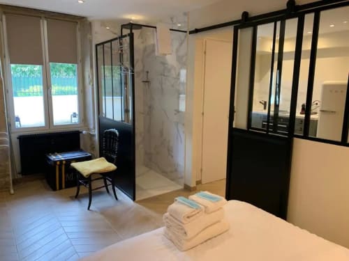 Chambre moderne avec salle d'eau attenante à la Conciergerie Des Climats, Beaune, avec paroi vitrée et vue sur la ville