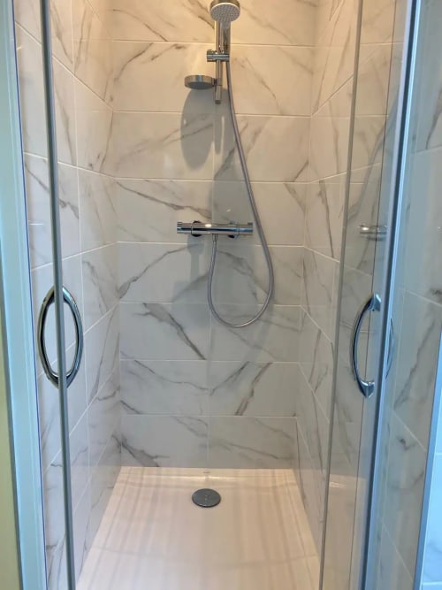 Douche à l'italienne moderne avec carrelage effet marbre, pomme de pluie et douchette à main à la villa Conciergerie Des Climats