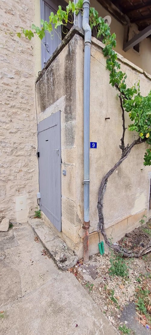 Élégante entrée de villa en pierre à Beaune, façade patinée, porte verte numéro 9, vignes grimpantes à la Conciergerie Des
