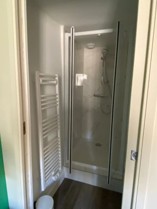 Salle de bain moderne avec douche à l'italienne, porte-serviettes chauffant et pluie de douche à la Conciergerie Des Climats à Beaune