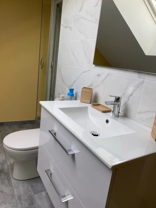 Salle de bains moderne à la villa Conciergerie Des Climats à Beaune avec vasque blanche, toilettes et dosseret en marbre