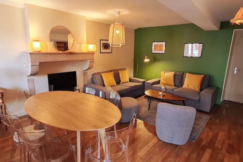 Villa à Beaune avec espace ouvert, salle à manger et salon intégrés, mobilier moderne, mur d'accent vert, cheminée, ambiance chaleureuse