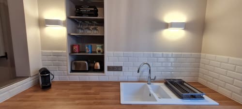 Kitchenette moderne dans un appartement à Beaune avec carrelage blanc métro, plan de travail en bois, évier et étagères ouvertes