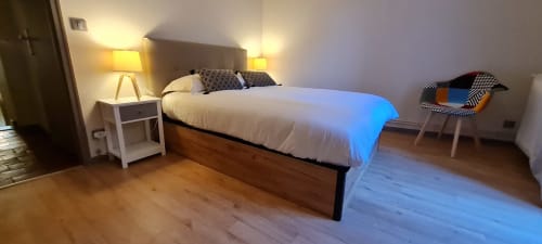 Chambre moderne à la Conciergerie Des Climats à Beaune avec lit, lampes de chevet, parquet et coin salon
