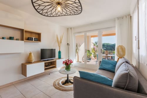 Salon avec canapé et TV de l'appartement La Girelle - Vacances Giens location saisonnière d'appartement - Proche de l'embarcadère pour l'île de Porquerolles.