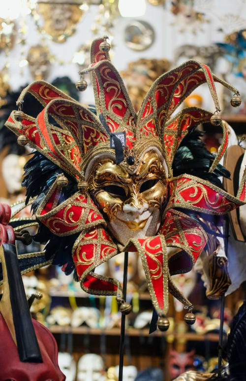 Ornate red and gold Venetian jester mask with bells at Hotel Ariel Silva Venice apartments in Cannaregio, Italy