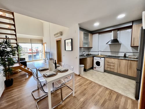 Cocina y comedor modernos en los Apartamentos J&A en Terrassa con electrodomésticos de acero inoxidable