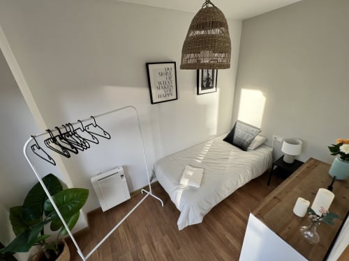 Habitación compacta en Apartments J&A en Terrassa con cama blanca, lámpara colgante tejida y suelo de madera