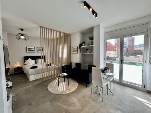 Estudio moderno en Apartamentos J&A en Terrassa con cama, sofá, zona de comedor y vistas al balcón