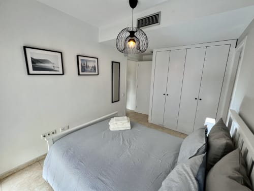 Dormitorio moderno en J&A Apartments en Terrassa con cama, armarios blancos y decoración minimalista