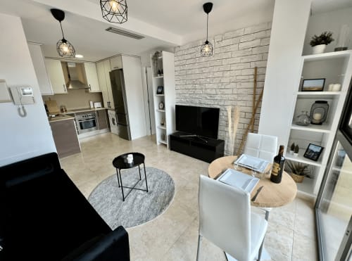 Apartamento moderno de planta abierta en Terrassa con cocina, sala de estar, chimenea de ladrillo y mesa de comedor en J&A APARTMENTS