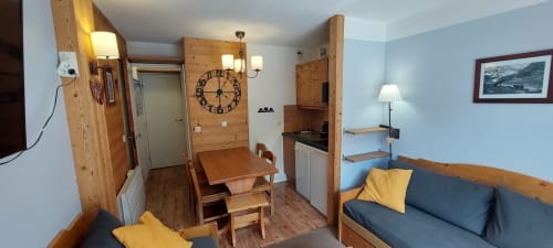 Appartement cosy à CMD Méribel Le Pralin avec mobilier bois, coin repas, kitchenette et salon confortable