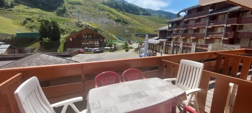 Sièges sur balcon au CMD Méribel Le Pralin avec vue sur les Alpes et les bâtiments de la station à Méribel, France