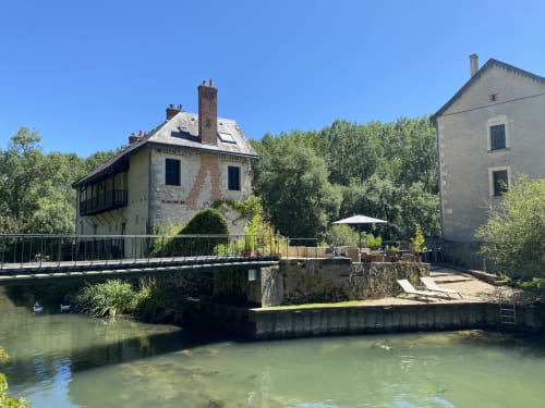 Moulin De La Chevrière watermill B&B in Saché, France with stone buildings beside peaceful river
