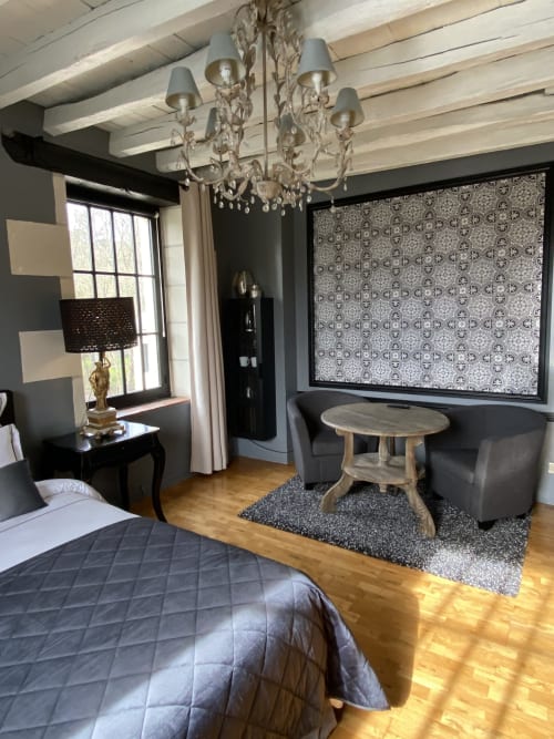 Chambre élégante au Moulin De La Chevrière avec lustre, poutres apparentes, cheminée et mobilier moderne à Saché