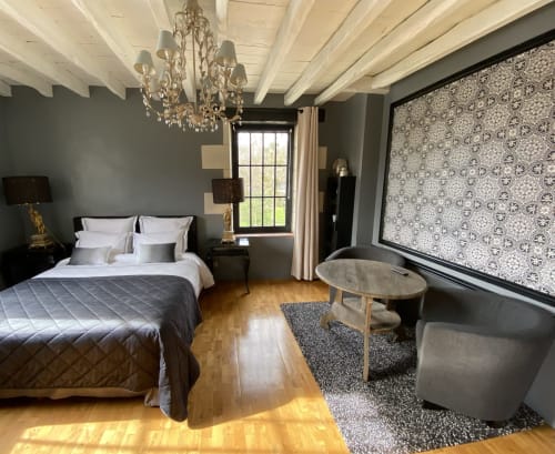 Chambre élégante au Moulin De La Chevrière avec poutres apparentes, lustre en cristal et coin détente moderne