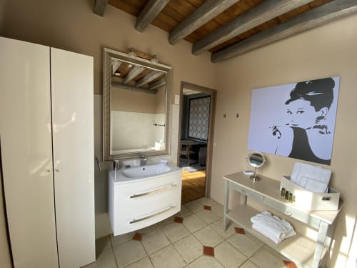 Salle de bains moderne au Moulin De La Chevrière avec vasque blanche, miroir et art pop vintage à Saché