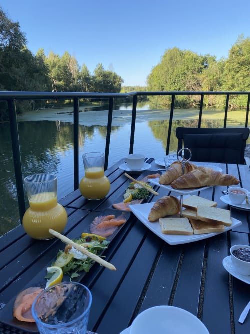 Petit-déjeuner au bord de la rivière au Moulin De La Chevrière avec croissants, jus de fruit et saumon fumé surplombant la vallée de la Loire