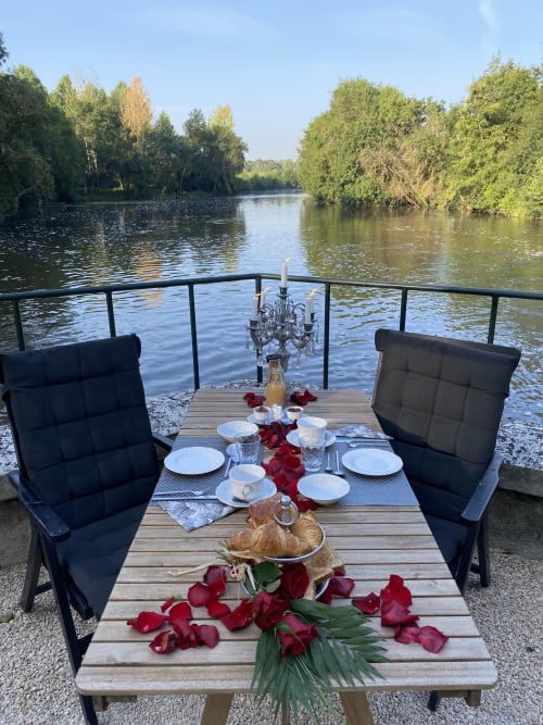 Dîner romantique au bord de la Loire au Moulin De La Chevrière : table aux chandelles, pétales de roses rouges, paysage boisé