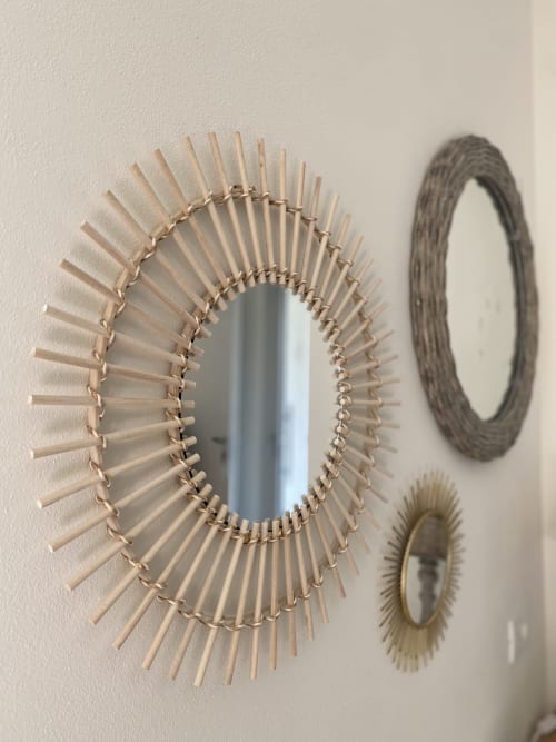 Decorative woven mirrors on beige wall at Verdolivo bed and breakfast in Sale Marasino, Italy