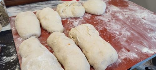 Fresh bread dough portions on red floured surface at Kindnessmoon guesthouse, Óbidos Portugal