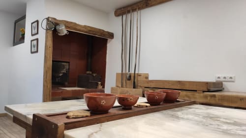 Rustic Portuguese kitchen at Kindnessmoon in Óbidos with traditional wooden beams, terracotta bowls, and stone countertops