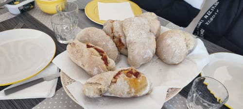 Freshly baked Portuguese bread rolls served at Kindnessmoon guesthouse in Óbidos, with dining table setup