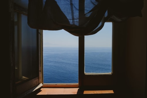 Vista sul mare dalla camera Palazzo Porta a Procida, Italia con finestre aperte sul blu Mar Mediterraneo