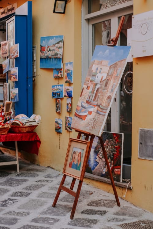 Colorati dipinti e opere d'arte esposte all'esterno del Palazzo Porta BnB a Procida, Italia