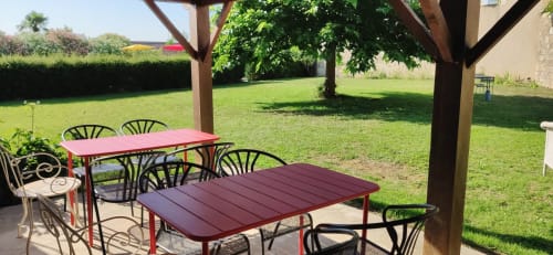 Cuisine d’été du Rêve d’Alice avec tables et chaises sous pergola, au cœur du jardin verdoyant