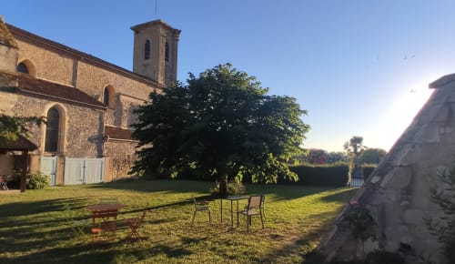 Grand jardin arboré du Rêve d’Alice avec vue sur la bâtisse en pierre et l’environnement rural