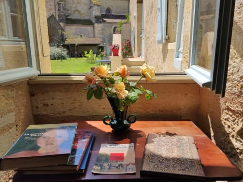 Coin lecture près de la fenêtre dans la salle petits déjeuners du Rêve d’Alice, vue sur la cour en pierre