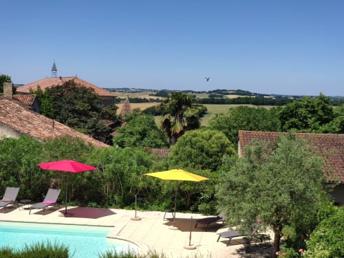Vue panoramique depuis la piscine du Rêve d’Alice sur les collines vallonnées de la campagne gersoise.