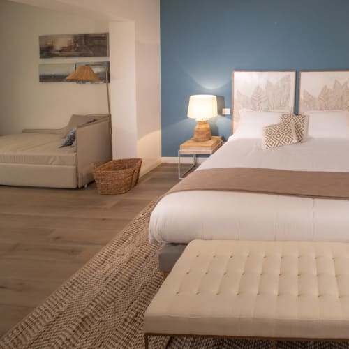 Verdolivo guesthouse bedroom in Sale Marasino with twin beds, blue accent wall, wooden floor and modern décor
