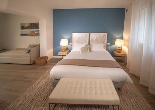 Schlafzimmer des Verdolivo B&B in Sale Marasino mit blauer Akzentwand, weißer Bettwäsche und Holzboden