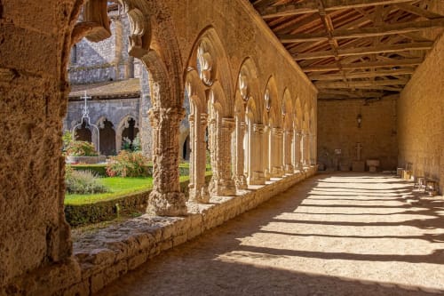 Cloître médiéval en pierre avec colonnade voûtée et jardin de cour à Le Rêve d'Alice à Saint-Puy, France
