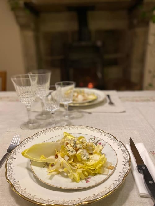 Élégante table de restaurant à La Maison De Fleurat avec assiette de pâtes, verres en cristal et porcelaine fine