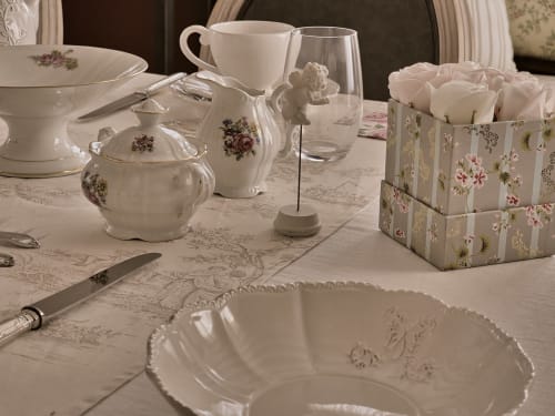Élégante table de salle à manger au Manoir Le Coutureau avec porcelaine fine, roses blanches et vaisselle à motifs floraux à Rouffignac