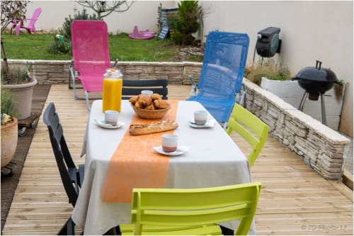 Petit-déjeuner en terrasse au gîte Le Pirate Benèze à Trizay avec chaises colorées, croissants et jus