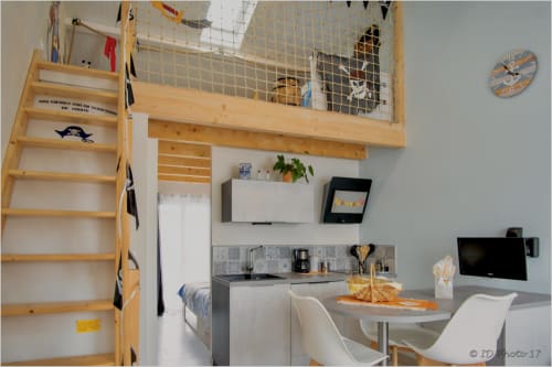 Studio cosy à Le Pirate Benèze à Trizay : chambre en mezzanine, kitchenette, coin repas et TV