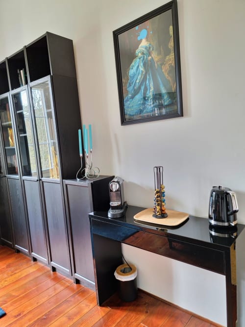 Coin cuisine moderne au Manoir Le Coutureau avec meubles noirs, cafetière et tableau portrait