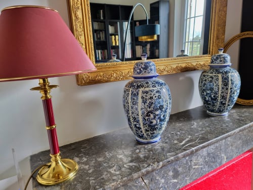 Élégante cheminée au Manoir Le Coutureau avec potiches bleues en porcelaine, lampe en laiton et miroir ornementé