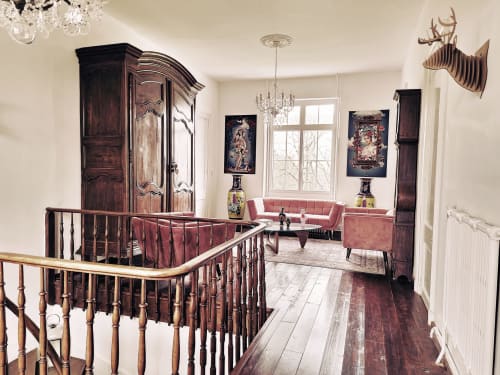 Palier élégant du Manoir Le Coutureau avec escalier en bois, mobilier ancien et sièges en velours rose