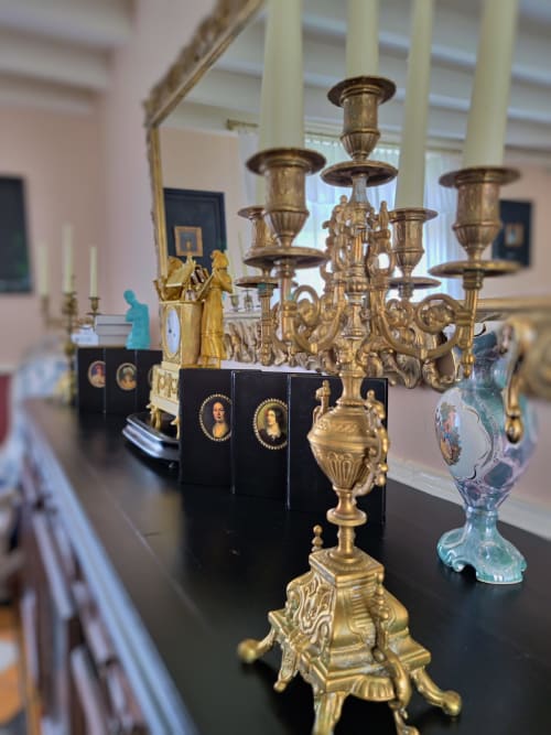 Somptueux candélabre doré et objets décoratifs exposés dans l'élégante galerie du Manoir Le Coutureau, domaine français.