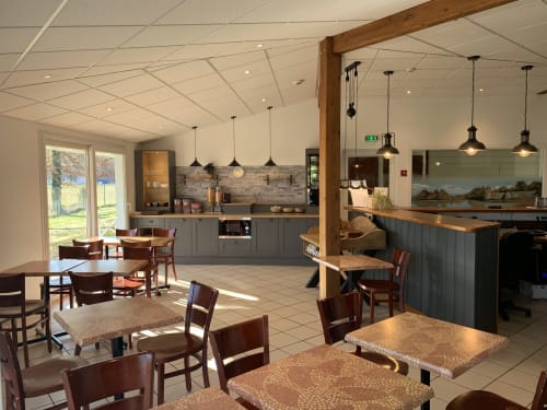 Salle à manger de l'Hôtel Mape à Dampierre-en-Burghy avec cuisine moderne, poutres en bois, luminaires suspendus et accès à la terrasse