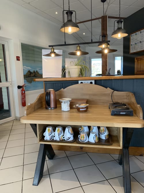 Réception de l'hôtel Mape à Dampierre en Burly avec comptoir en bois, luminaires suspendus et équipements d'accueil