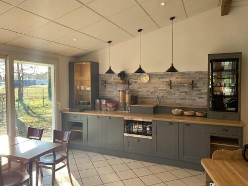 Cuisine contemporaine de l'hôtel Mape à Dampierre en Burly avec mobilier gris, plan de travail en bois et luminaires suspendus