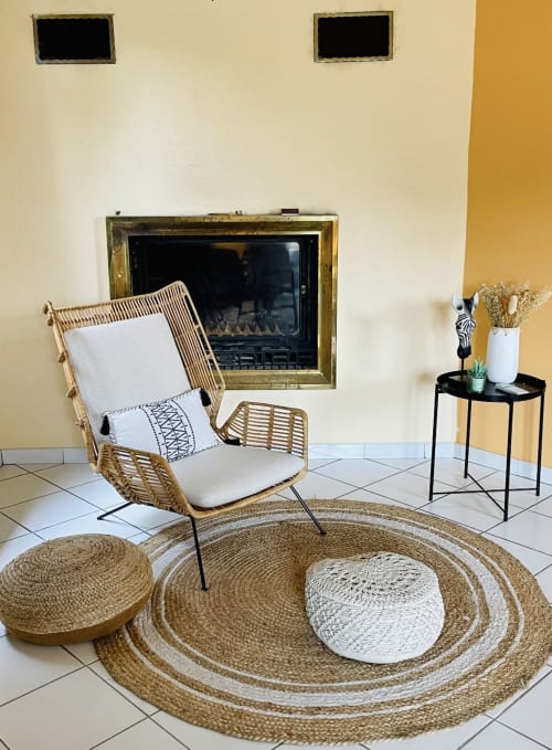 Gemütlicher Sitzbereich in der Villa Moka mit Korbstuhl, Kamin und natürlicher Dekoration