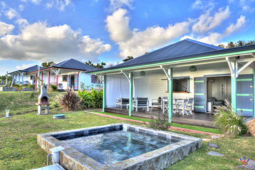 Colorful cottage with green trim at Le Domaine De L'ilet, Guadeloupe, featuring pool and sea view