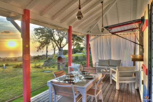 Sunset view from Kaz'Mussaenda cottage at Le Domaine De L'ilet in Guadeloupe, featuring dining area and lounge with sea view